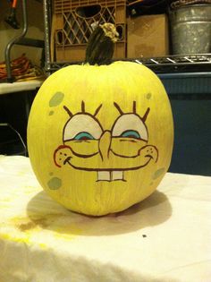 a yellow painted pumpkin sitting on top of a table