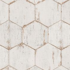 an old white hexagonal tile wallpaper with peeling paint on the edges and sides