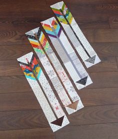 four skis laying on top of a wooden floor next to each other with different designs