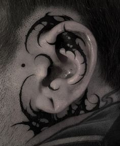 a close up of a man's ear with tattoos on it