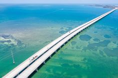 an aerial view of a large bridge spanning the width of blue water and coral reefs