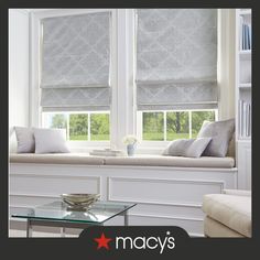 a living room filled with furniture and windows covered in roman blind shades on the window sill