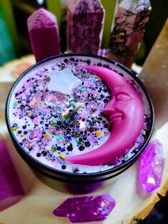 a cup filled with purple liquid and lots of sprinkles on top of it