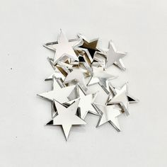 a pile of silver stars sitting on top of a white table