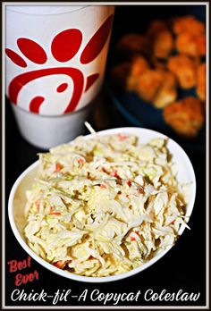 a white bowl filled with coleslaw next to a cup