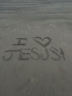 i love jesus written in the sand with a heart drawn on it's side