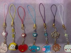 several key chains with cartoon characters on them are lined up against a purple background,