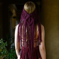 a woman with long blonde hair wearing a purple crochet dress and braids