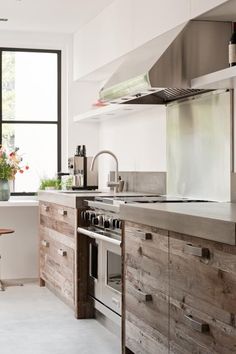 a kitchen with an oven, sink and counter tops made out of wooden planks