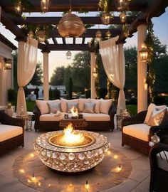 a fire pit sitting on top of a stone patio surrounded by chairs and tables covered in lights