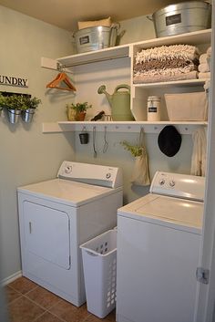 a washer and dryer in a small room with open shelving above them