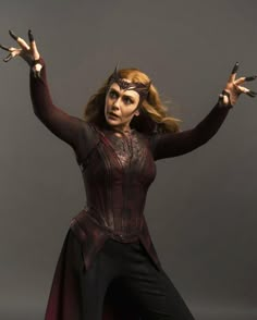 a woman dressed as catwoman with her hands in the air and two fingers out