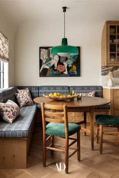 a kitchen table with two chairs and a bench in front of it, next to a painting on the wall