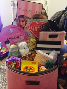 a pink suitcase filled with lots of different types of items in front of a sign