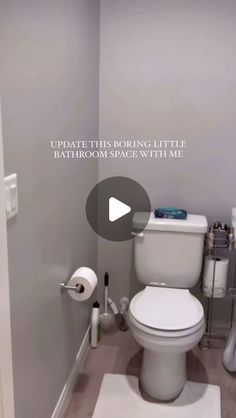 a white toilet sitting inside of a bathroom next to a roll of toilet paper on the floor