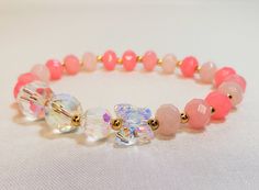 "This bracelet is made of crystals and glass. Featuring vibrant crystal beads, a high quality iridescent butterfly crystal charm, ombre pink glass beads and 14 kt gold plated accent beads. With its versatile bead assortment, this bracelet goes with any outfit. You will be able to show off your unique style and make your wrist the center of attention. Most of my bracelets fit wrists between 6\" and 6.5\" in size. Before placing an order, please confirm your size. Thank you" Pink Crystal Beaded Bracelets With Round Beads, Pink Crystal Beaded Bracelets With Faceted Beads, Pink Crystal Beaded Bracelet With Faceted Beads, Elegant Pink Crystal Bracelet With Colorful Beads, Elegant Pink Dangle Charm Bracelet, Pink Flower-shaped Beaded Charm Bracelet, Adjustable Hand-strung Pink Crystal Bracelet, Pink Flower-shaped Adjustable Crystal Bracelet, Crystal Beads Bracelet