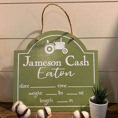 a green sign that says jameson cash eaton with cotton balls on the table next to it