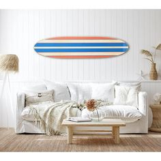 a living room filled with furniture and a surfboard on the wall above it's head