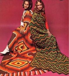 two women in crocheted dresses are posing for a magazine cover with an afghan on the floor