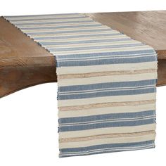 a blue and white striped table runner sitting on top of a wooden bench next to a piece of wood