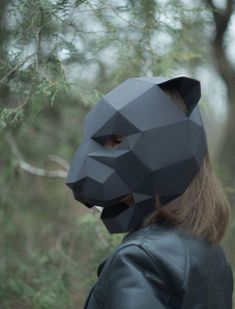 a person wearing a cat mask in the woods