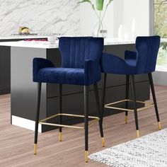 two blue velvet bar stools in front of a kitchen island with marble counter tops