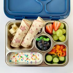 an open lunch box filled with fruit, crackers and veggies