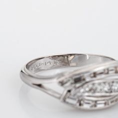 This is part of Chairish’s Fine Jewelry assortment.  Stylish vintage mixed cut diamond ring (circa 1950s to 1960s) crafted in 14 karat white gold.   Straight baguette and round brilliant cut diamonds total an estimated 0.33 carats (estimated at H-I colour and VS2-SI1 clarity).   Bright and lively baguette cut diamonds frame row of round brilliant cut diamonds to the centre. The ring is great worn as an alternative wedding or ring for everyday wear. The low rise ring (4mm - 0.15 inches) sits comf Modernist Sterling Silver Wedding Rings, White Diamond-cut Linked Jewelry, Modernist White Gold Diamond Jewelry, Luxury Modernist Diamond Rings, Vintage Baguette-cut Platinum Diamond Ring, Diamond Frame, Baguette Cut Diamond, Vintage Band, 14k White Gold Ring