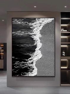 a large black and white painting hanging on the side of a wall in a living room