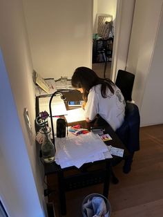 a woman sitting at a desk working on her computer