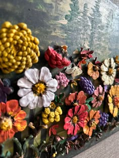 colorful flowers are arranged on the side of a painting