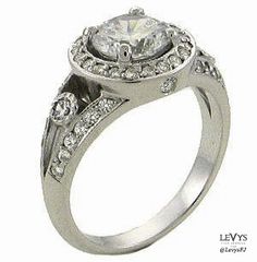 a white gold engagement ring with diamonds on the band and an oval shaped center stone