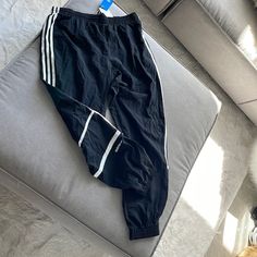 Black Men’s Adidas Running Pants With White Stripes. Brand New Adidas Joggers With Pockets For Streetwear, Adidas Streetwear Bottoms With Elastic Waistband, Sporty Black Tapered Leg Bottoms, Adidas Black Pants With Pockets, Adidas Black Pants For Streetwear, Adidas Casual Black Bottoms, Adidas Sporty Black Bottoms, Sporty Black Adidas Bottoms, Adidas Black Bottoms For Streetwear