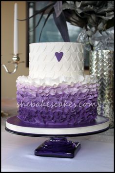 a three tiered cake with purple and white icing