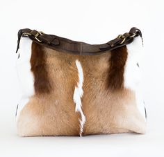 Genuine hair on antelope front panel with super soft Italian adobe brown back. The bag and shoulder strap are trimmed with brown bison and has a side zippered pocket and magnetic closure. Due to the natural product, variations in hides are to be expected and considered part of the beauty. Due to lighting used during photography, actual finishes may vary from imagery. Interior: Satin lined with cell phone pocket Dimensions: 19 x 13 x 4 Strap: 12 inch drop Made in the USA by Juan Antonio. Juan Ant Brown Calf Hair Shoulder Bag With Leather Handles, Brown Calf Hair Satchel Bags, Brown Calf Hair Satchel Shoulder Bag, Brown Calf Hair Tote Shoulder Bag, Exotic Hairstyles, Western Handbags, Tooled Leather Bag, Boho Handbags, Western Purses