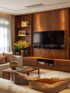 a living room filled with furniture and a flat screen tv mounted on a wall next to a window