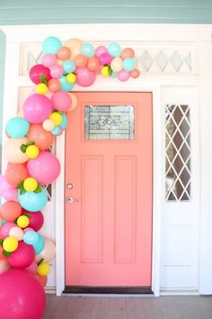 a pink front door decorated with balloons