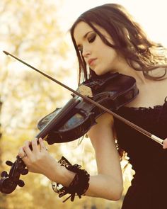 a woman in black dress holding a violin