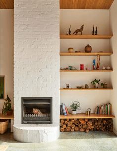 a living room filled with furniture and a fire place next to a white brick wall