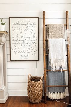 a wooden ladder sitting next to a basket on top of a hard wood floor in front of a white wall