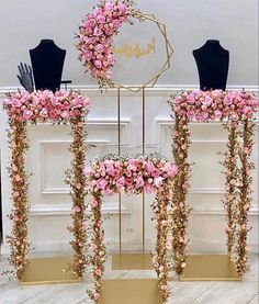 three mannequins decorated with pink flowers and greenery