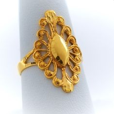 Anillo de mujer de oro 10k tipo almendra Este elegante anillo de mujer está elaborado en oro 10k de color amarillo y tiene un diseño tipo almendra grande que atrae las miradas. Su tamaño es ideal para ser lucido en los dedos índice o del medio, ya que es lo suficientemente largo para destacar en cualquier mano. Diseño delicado La pieza cuenta con un delicado calado que le añade un toque de sofisticación y belleza, lo que lo convierte en una joya perfecta para una ocasión especial o para compleme Elegant 22k Gold Filigree Ring, 14k Yellow Gold Ring With Elegant Design, Classic 22k Gold Oval Jewelry, 14k Gold Filigree Ring Fine Jewelry, Gold Oval Filigree Ring Hallmarked, Gold Filigree 14k Gold Rings, Gold Oval Filigree Ring, Gold Oval Ring With Diamond Cut, Oval Gold Filigree Ring With Diamond Cut