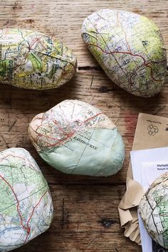 several pieces of paper sitting on top of a wooden table next to rocks and mail