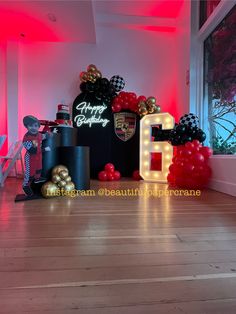 an image of a birthday party setting with balloons and letters on the floor in front of it