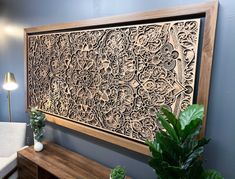 a large wooden panel with intricate designs on the wall next to a couch and table