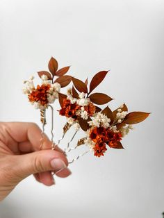 a person is holding some flowers in their hand and it looks like they are made out of real flowers