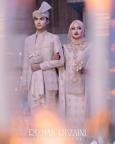 two people standing next to each other wearing white outfits