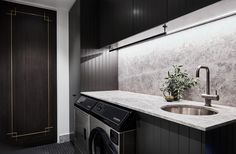 a washer and dryer in a room with dark wood paneling on the walls