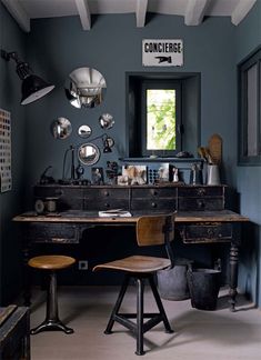 an old fashioned desk and chair in a room with blue walls, white beams and wooden floors