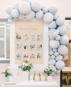 a table topped with white balloons and pictures